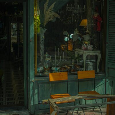 Charming antique store window showcasing vintage decor and furniture outside.