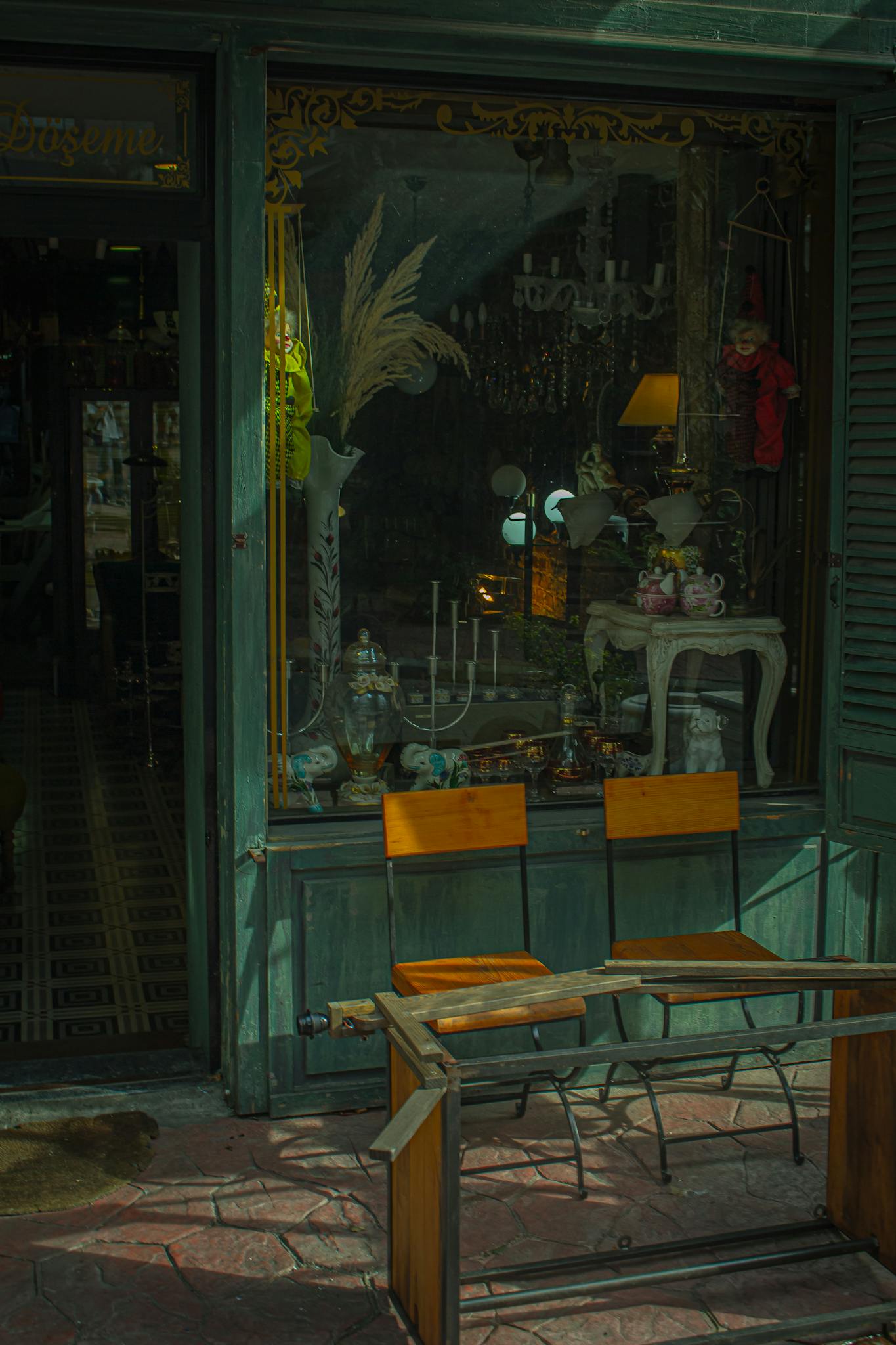 Charming antique store window showcasing vintage decor and furniture outside.