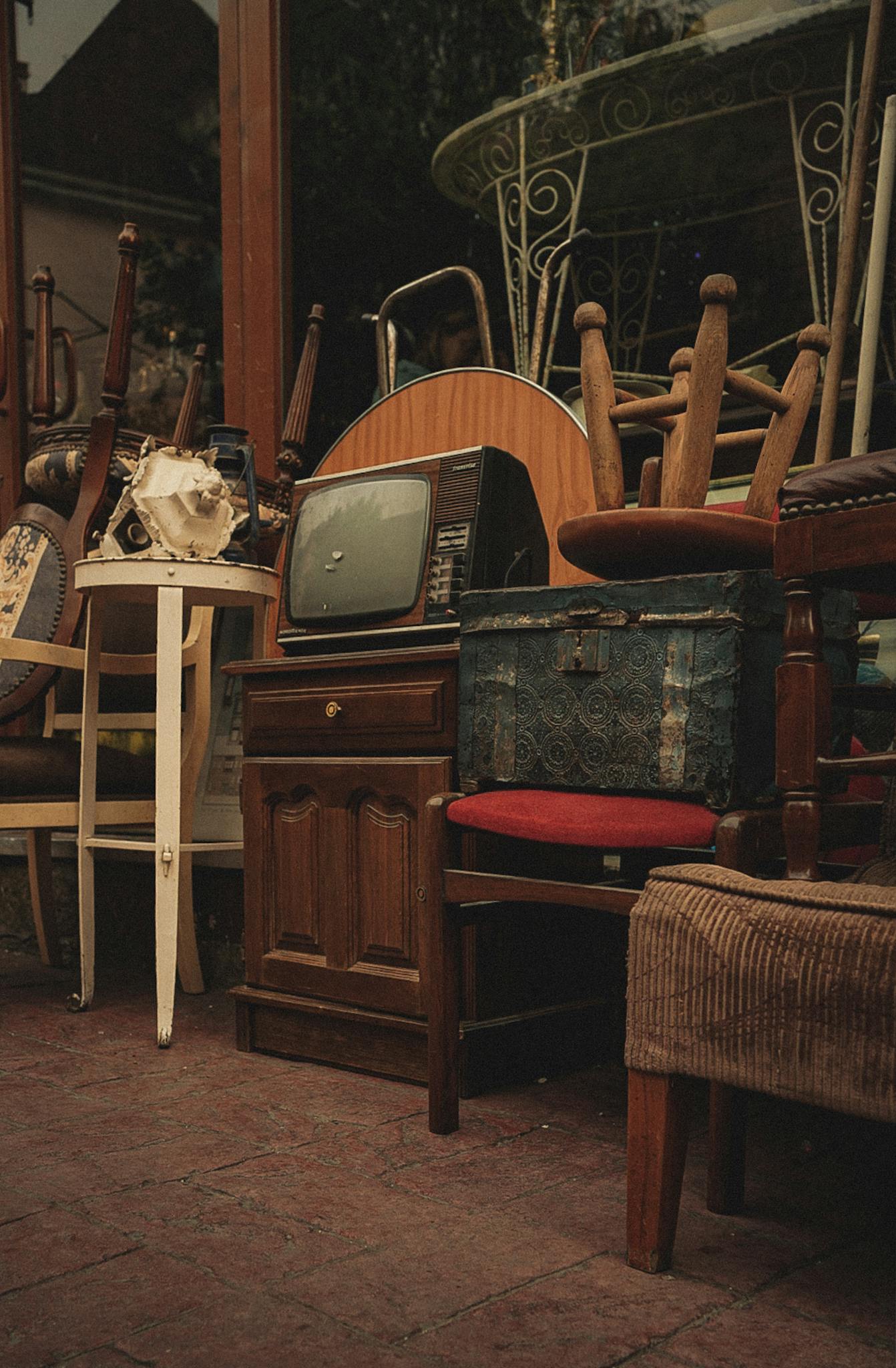 Eclectic mix of vintage furniture and antiques in a store with retro charm.